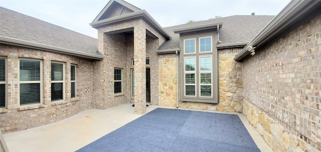 view of exterior entry with a patio