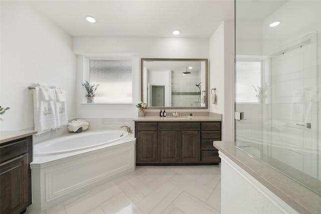 bathroom with vanity and separate shower and tub