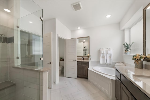 full bathroom featuring shower with separate bathtub, vanity, and toilet