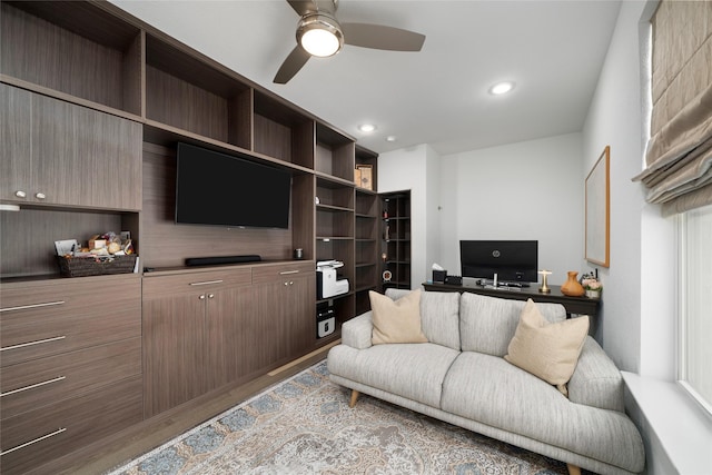 living room featuring light hardwood / wood-style flooring and ceiling fan