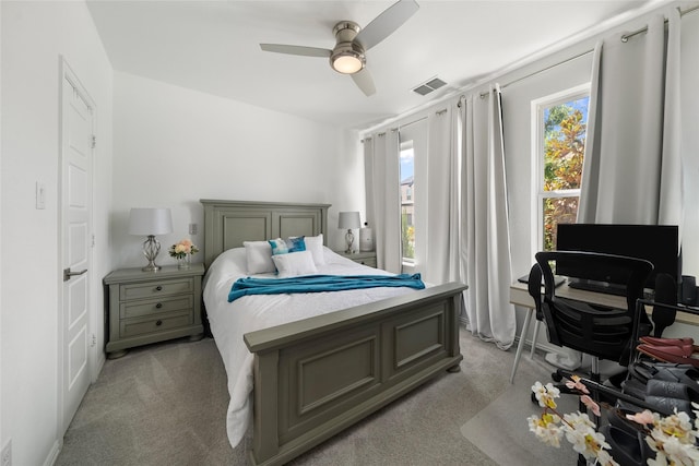 carpeted bedroom with ceiling fan and multiple windows