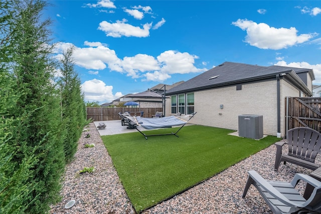 rear view of house with a yard, cooling unit, and a patio area