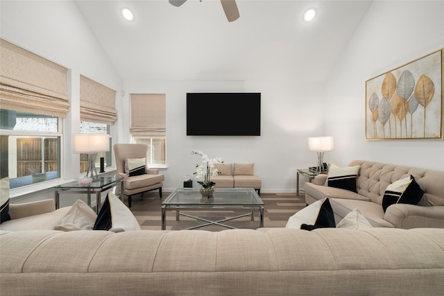 living room with hardwood / wood-style flooring, ceiling fan, and vaulted ceiling