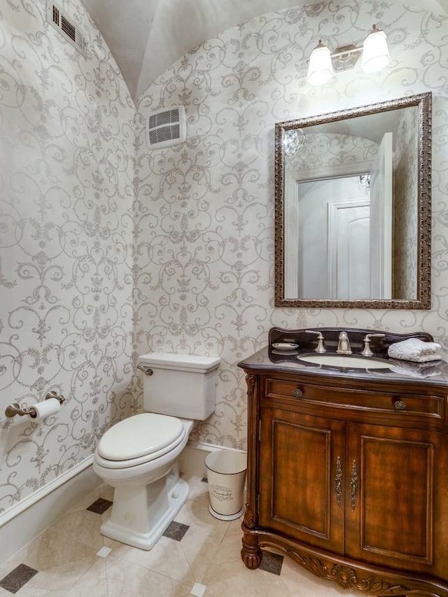 bathroom featuring toilet, lofted ceiling, and vanity