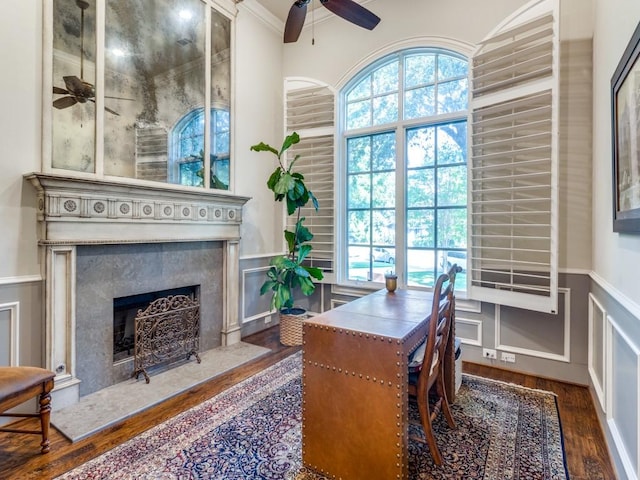 office space with dark hardwood / wood-style flooring, a high end fireplace, crown molding, and ceiling fan