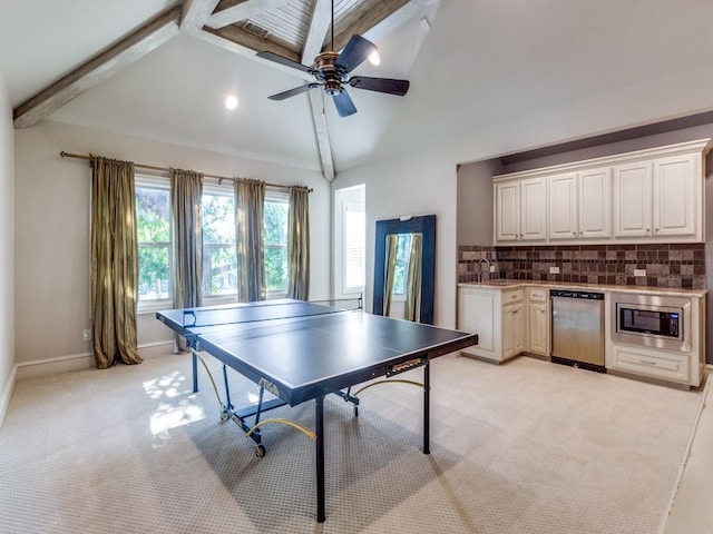 recreation room featuring light carpet, sink, beamed ceiling, and high vaulted ceiling