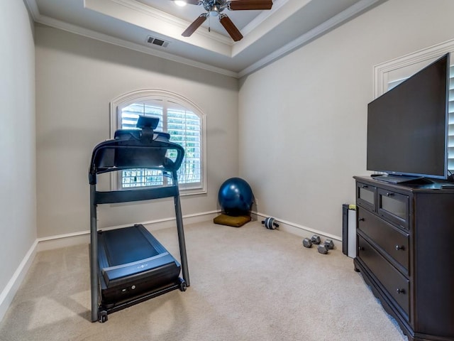 workout room featuring crown molding, light colored carpet, a tray ceiling, and ceiling fan