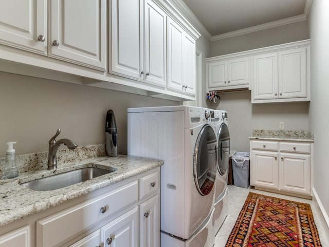 laundry area featuring cabinets, ornamental molding, sink, and washing machine and clothes dryer