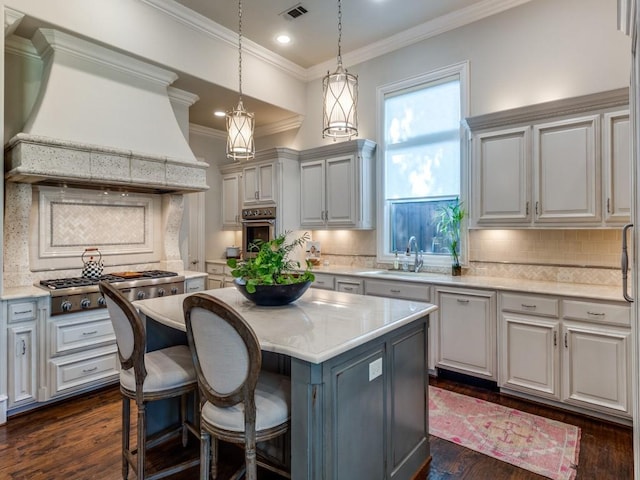 kitchen with a center island, appliances with stainless steel finishes, tasteful backsplash, premium range hood, and pendant lighting