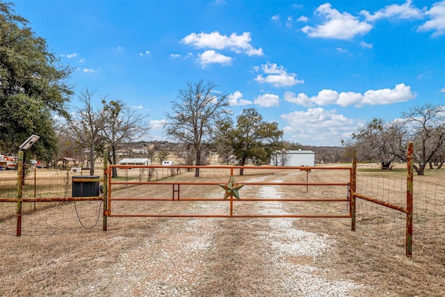 view of gate with a rural view