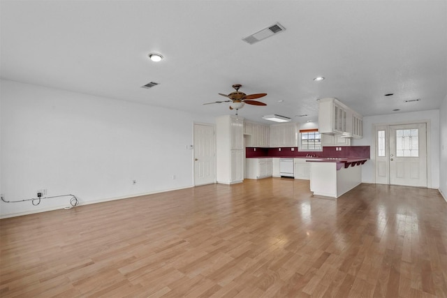 unfurnished living room with light hardwood / wood-style flooring and ceiling fan