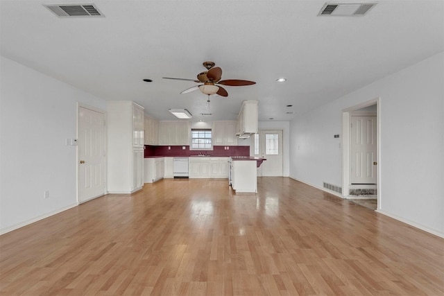 unfurnished living room with light hardwood / wood-style floors, sink, and ceiling fan