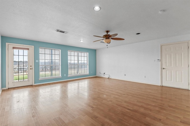 spare room with light hardwood / wood-style floors, a textured ceiling, and ceiling fan