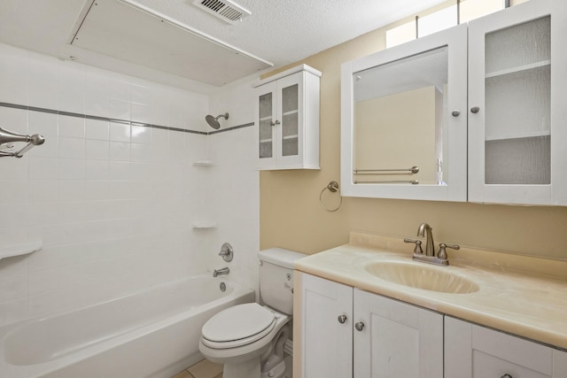 full bathroom with a textured ceiling, tiled shower / bath combo, vanity, and toilet