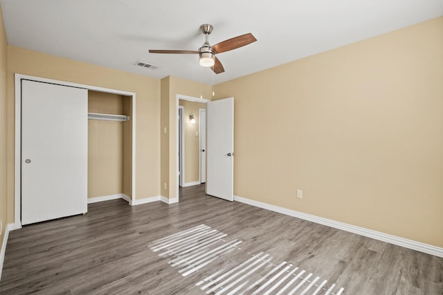 unfurnished bedroom with ceiling fan, hardwood / wood-style flooring, and a closet