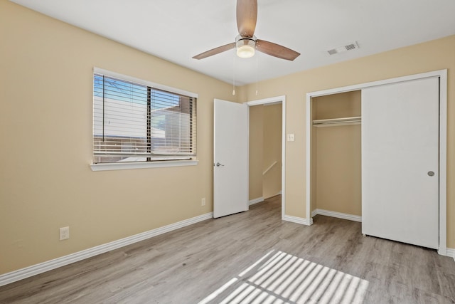 unfurnished bedroom featuring light hardwood / wood-style flooring, a closet, and ceiling fan