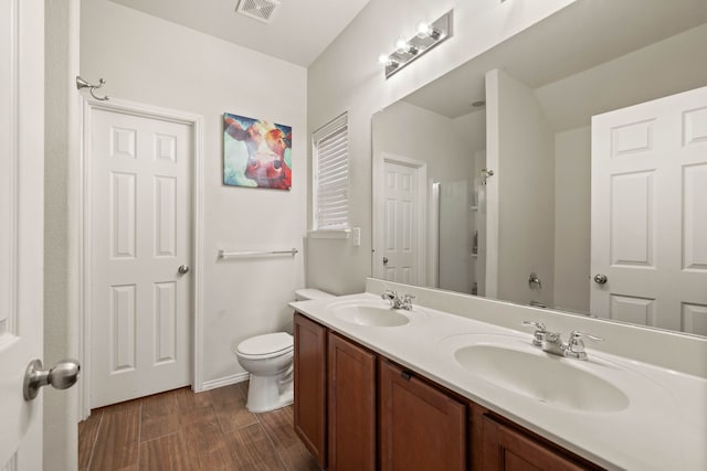 bathroom with toilet, an enclosed shower, visible vents, and a sink