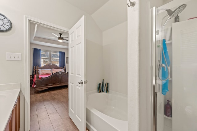 ensuite bathroom featuring a washtub, wood tiled floor, ceiling fan, vanity, and ensuite bath