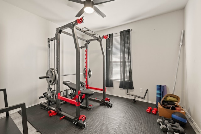 exercise room with ceiling fan and baseboards