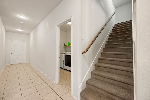 stairway featuring baseboards, washer and clothes dryer, and tile patterned floors