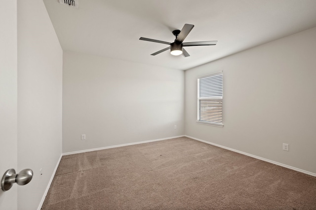 carpeted empty room with ceiling fan, visible vents, and baseboards