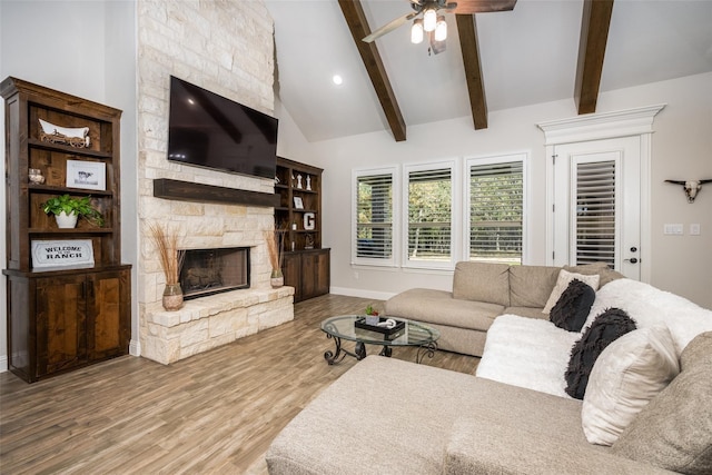 living room featuring a fireplace, wood-type flooring, high vaulted ceiling, beam ceiling, and ceiling fan