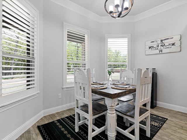 dining space featuring crown molding, hardwood / wood-style floors, and a chandelier