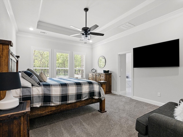 carpeted bedroom featuring ceiling fan, crown molding, ensuite bath, and a tray ceiling