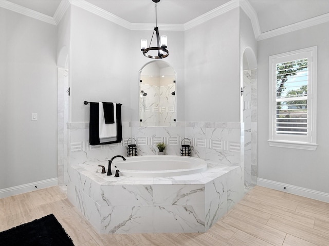 bathroom featuring independent shower and bath, an inviting chandelier, and ornamental molding