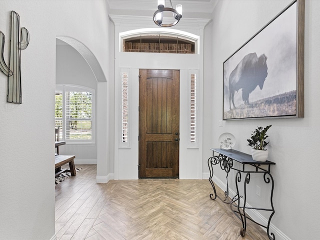 entryway featuring light parquet floors and an inviting chandelier