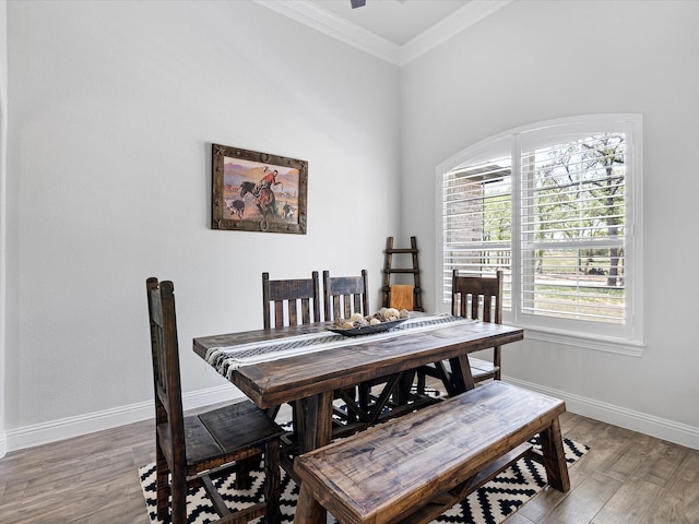 dining area with hardwood / wood-style flooring and ornamental molding