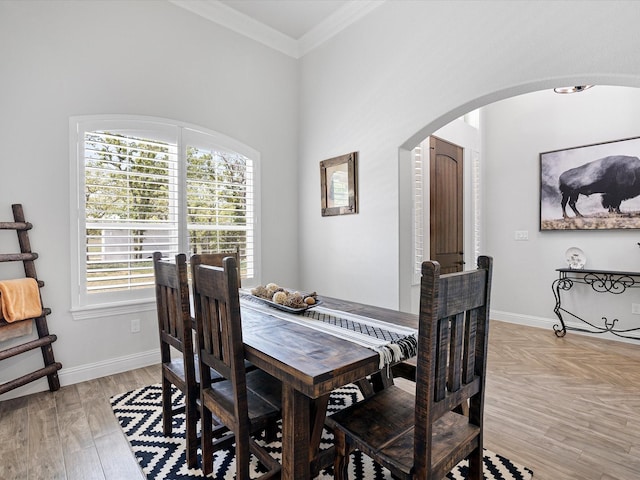 dining area featuring crown molding, a healthy amount of sunlight, and light wood-type flooring