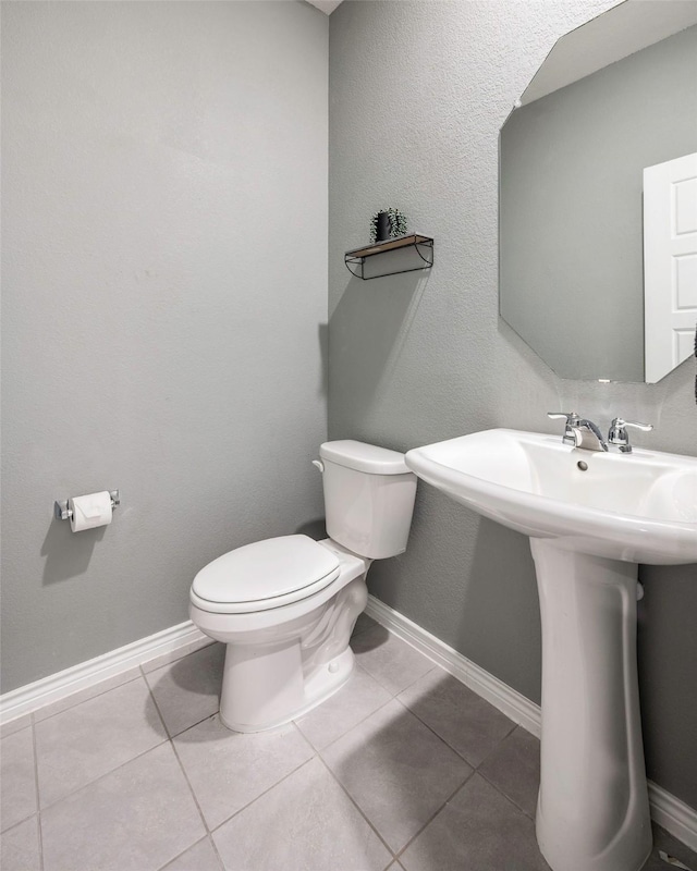 bathroom with toilet and tile patterned flooring