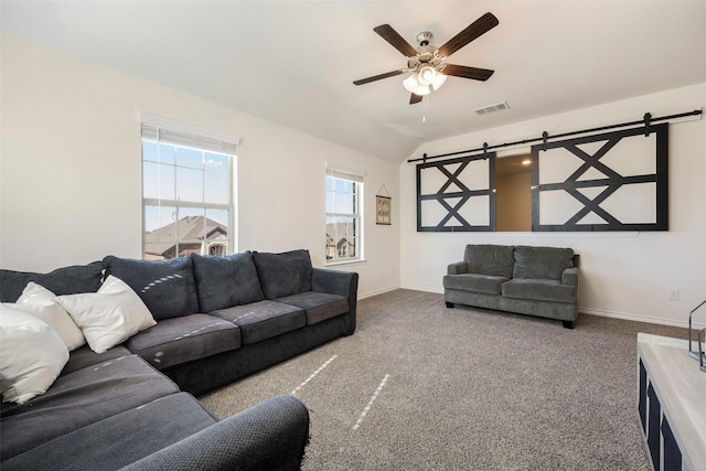 carpeted living room featuring vaulted ceiling, a barn door, and ceiling fan