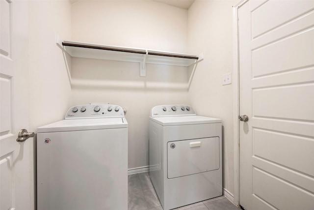 laundry area featuring washing machine and dryer and light tile patterned floors