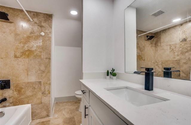 full bathroom with vanity, toilet, and tiled shower / bath