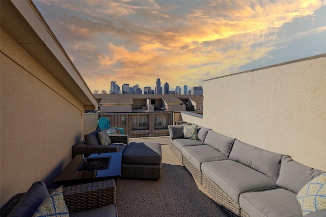 patio terrace at dusk with an outdoor living space with a fire pit