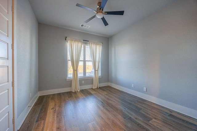 empty room with ceiling fan and dark hardwood / wood-style floors