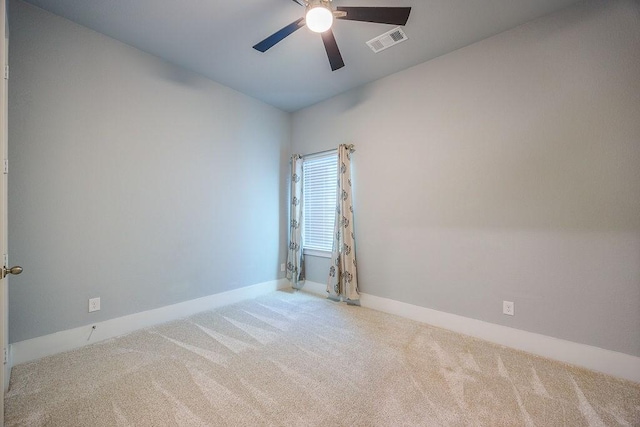 spare room with ceiling fan and light colored carpet