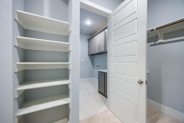 walk in closet featuring light carpet