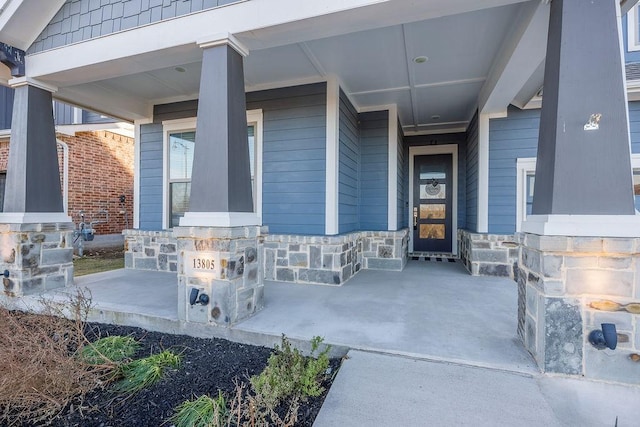 view of exterior entry featuring covered porch