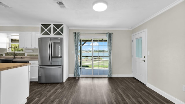 kitchen featuring white cabinetry, dark hardwood / wood-style flooring, butcher block countertops, stainless steel fridge, and sink