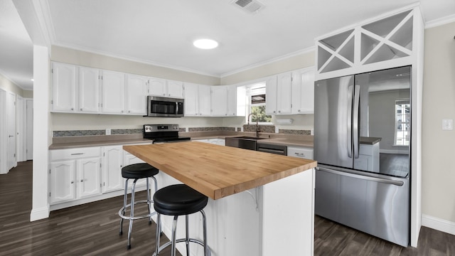 kitchen with sink, appliances with stainless steel finishes, white cabinets, and a center island