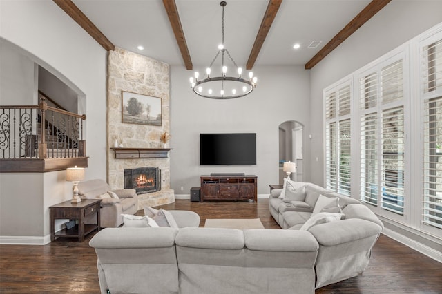 living room featuring dark wood-type flooring, beamed ceiling, and a fireplace