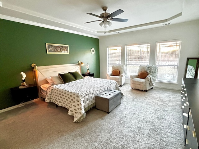 carpeted bedroom with multiple windows, ornamental molding, a raised ceiling, and ceiling fan