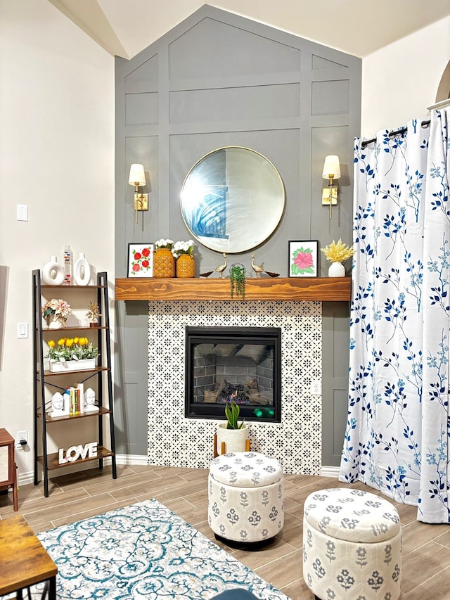 living room featuring a tiled fireplace and vaulted ceiling