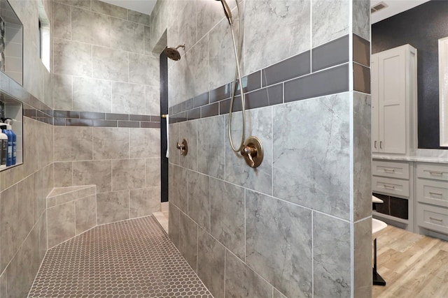 bathroom featuring a tile shower and hardwood / wood-style flooring