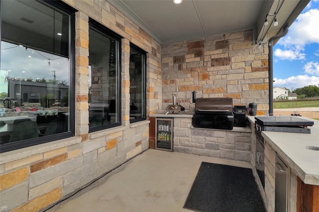 view of patio / terrace with exterior kitchen, wine cooler, and a grill