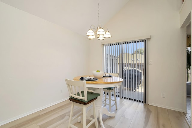 dining space featuring high vaulted ceiling, a chandelier, and light wood-type flooring