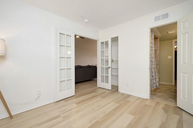 unfurnished room featuring light wood-type flooring and french doors